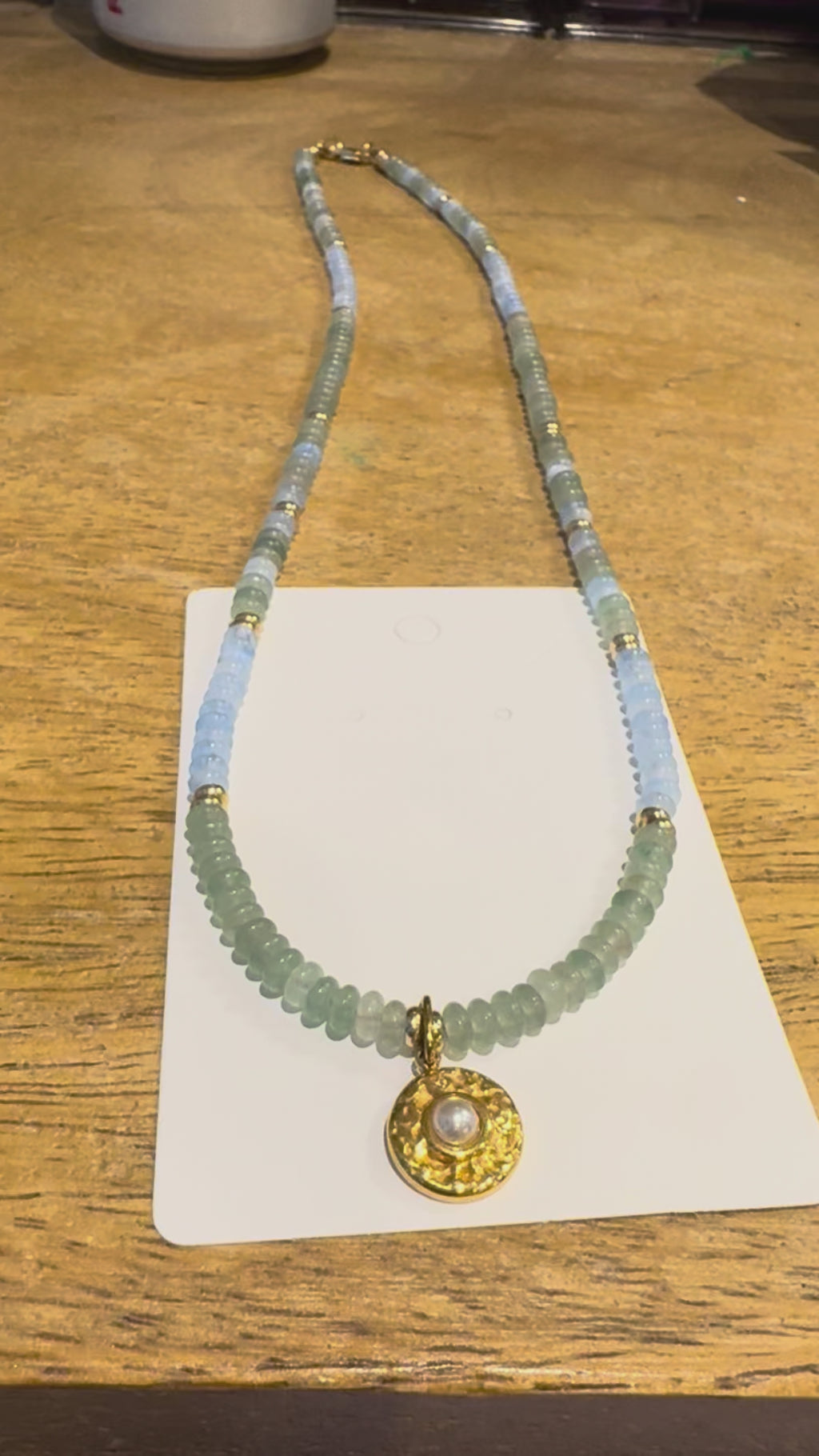 18in blue and green beaded necklace with gold plated pearl charm.